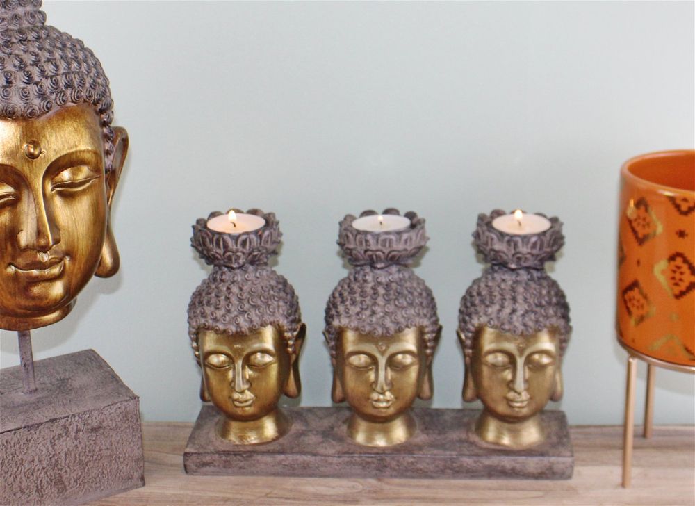 Tripple Buddha head holder with tealight candles on desk