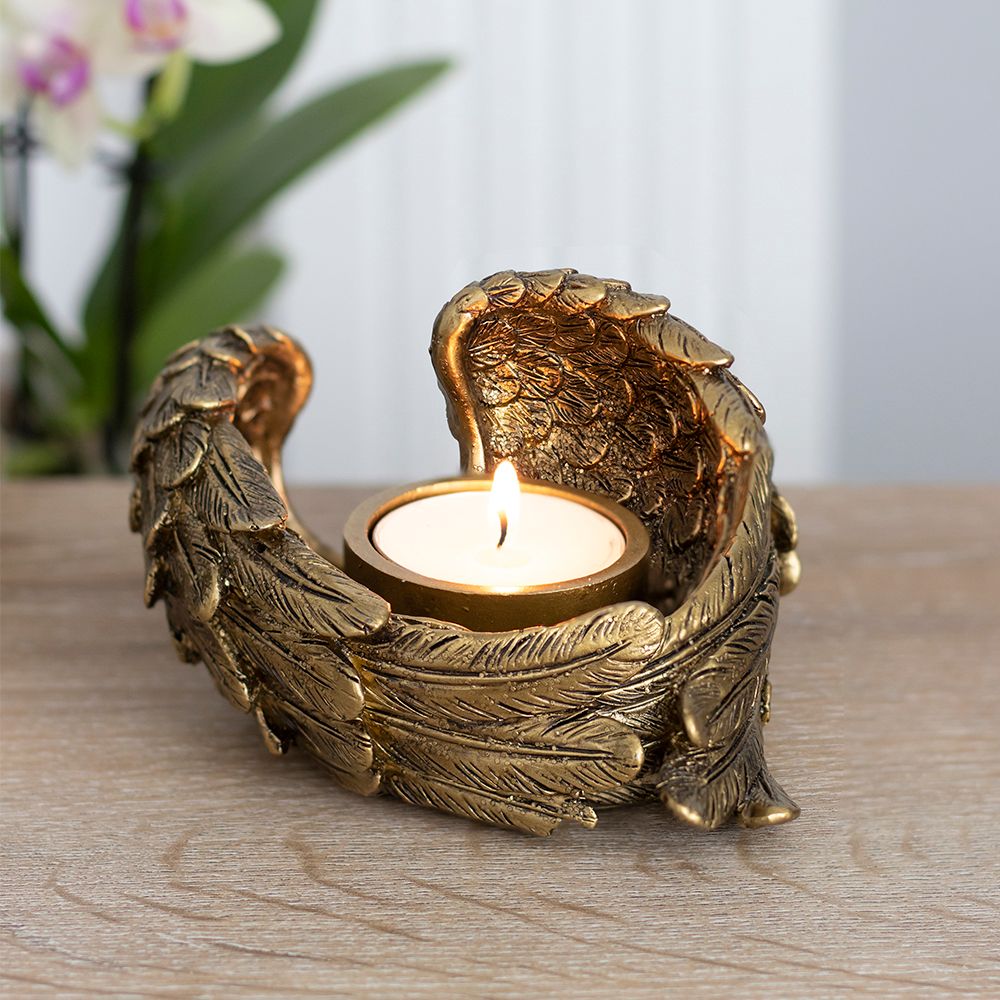 Gold angel wing tealight candle holder on desk